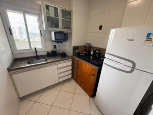 eine kleine Küche mit Kühlschrank und Spüle in der Unterkunft Apartamento no Centro de Sorocaba com vaga de garagem in Sorocaba