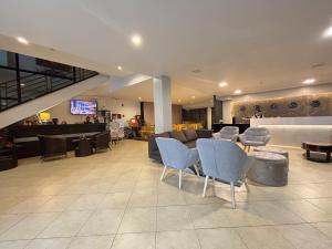 un vestíbulo con sofás, sillas y TV en D' Leonor Hotel, en Davao City