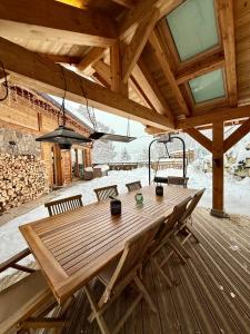 uma mesa de madeira no convés de uma cabine em Chalet Grand Area em Briançon