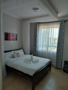 内罗毕Amalia Apartment syokimau的一间带大床的卧室，带窗户 更多17张照片