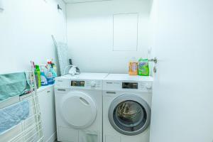 una lavadora y secadora blancas en una lavandería en Fancy 2BR & 1LR Apartment Panoramic Sky View, en Nivy 17 fotos más