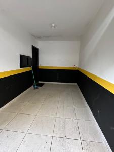 ein leerer Raum mit einer weißen Wand und einem Wischmopp in der Unterkunft Motel Vitoria Reggia in São Vicente
