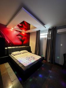 ein Zimmer mit einem Bett und einem Gemälde an der Wand in der Unterkunft Motel Vitoria Reggia in São Vicente + 1 Foto