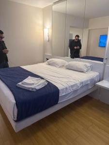 Un hombre tomando una fotografía de una cama en una habitación. en Orbi city d block, en Batumi