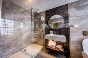 a bathroom with a shower and a sink and a mirror at Walled City Hotel in Derry Londonderry +25 photos