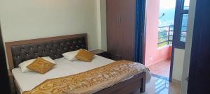een bed met twee kussens erop in een kamer bij Mountain Breeze 2BHK with a spectacular view in Bhowāli