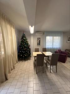 a christmas tree in a living room with a table and chairs at Residence Parmigianino in Parma