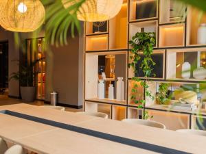 a restaurant with a table and chairs and plants at ibis Navegantes Itajai in Itajaí