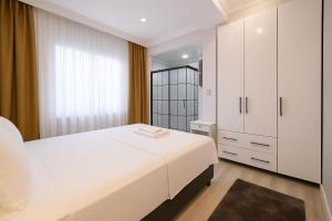 a bedroom with a white bed and a large window at Casa Florya Suites in Istanbul