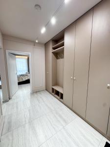 an empty room with white cabinets and a tile floor at Sky Escape - Private Parking, Kingsize Bed & More in Cluj-Napoca