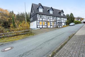 ein Schwarz-Weiß-Gebäude an der Straßenseite in der Unterkunft Ferienwohnung Küsterland in Assinghausen