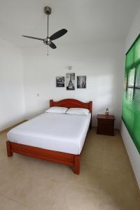 拉米萨Oasis de Colombia的一间卧室，里面有一张床和一个吊扇
