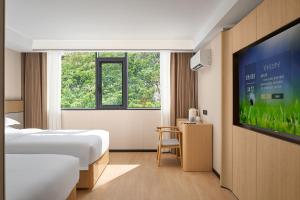 Una televisión o centro de entretenimiento en Baiyun airport KongGang airport hotel -24hours ree shuttle bus