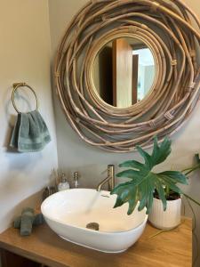 a bathroom with a white sink and a mirror at Weaver's Nest Cottage - Nature Escape in Gqeberha +90 photos
