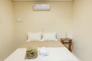 una camera da letto con un letto con asciugamani sopra di Container Azul na beira do rio e a poucos metros do mar a Belmonte