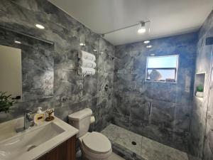 a bathroom with a toilet and a sink and a shower at Day Dreams Key Largo in Key Largo