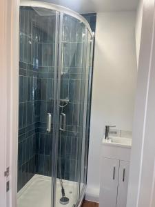 Woodfield Cottage Crawley 3 BR,Parking,Wifi,Garden, nearby Gatwick Airport, Contractor friendly, temporary relocations, business travellers, families في كراولي: دش زجاجي في حمام به حوض غسيل