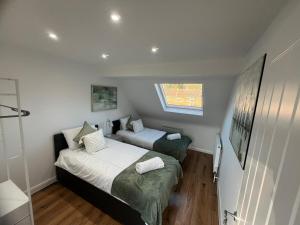 Woodfield Cottage Crawley 3 BR,Parking,Wifi,Garden, nearby Gatwick Airport, Contractor friendly, temporary relocations, business travellers, families في كراولي: غرفة نوم صغيرة بسريرين ونافذة