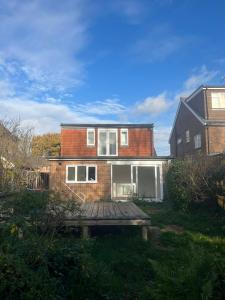 Woodfield Cottage Crawley 3 BR,Parking,Wifi,Garden, nearby Gatwick Airport, Contractor friendly, temporary relocations, business travellers, families في كراولي: منزل من الطوب وسطح خشبي في الفناء