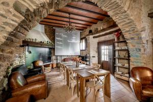 a dining room with a table and leather chairs at Hotel Mas la Ferreria in La Vall de Bianya