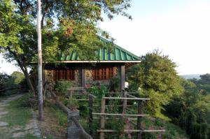 a small house with a green roof on a hill at Lei Thar Gone Guest House in Yenangyaung