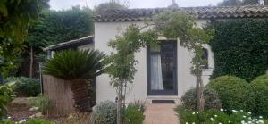 勒卡内Petite maison dans le jardin的一间白色的小房子,设有蓝色的门