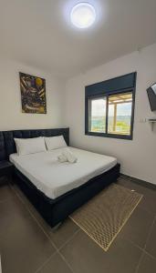 Un dormitorio con una cama grande con ventana. en סוויטת אפנדי, en Ya‘ara