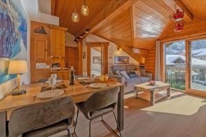 La Ginabelle - Sauna & Swimming pool - Happy Rentals في شامونيه مون بلان: غرفة طعام وغرفة معيشة مع طاولة وكراسي