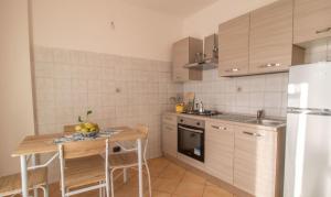 a kitchen with a table and a refrigerator and a sink at Casa Maresol Formia a 5 minuti a piedi dal mare in Trivio
