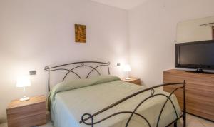 a bedroom with a bed and a flat screen tv at Casa Maresol Formia a 5 minuti a piedi dal mare in Trivio +14 photos