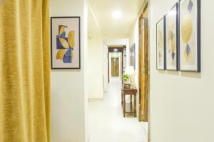 Un pasillo con cortinas amarillas y cuadros en las paredes. en FabExpress Gargi Executive - Shaniwar wada, en Pune