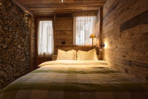 una camera da letto con un letto grande con una parete in legno di Alpine Woodhouse a Valtournenche