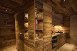 una cucina con pareti in legno e una libreria di Alpine Woodhouse a Valtournenche Altre 39 foto