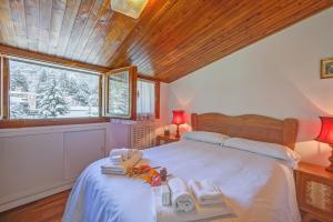 a bedroom with a large bed with towels on it at Il Rododendro City Center - Happy Rentals in Bardonecchia