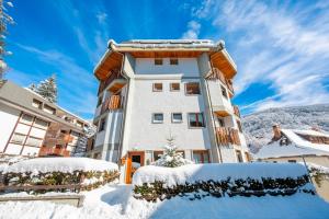 a building with snow in front of it at Il Rododendro City Center - Happy Rentals in Bardonecchia +17 photos