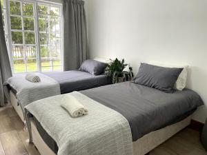 two beds in a room with a window at The White House in George