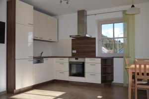 a kitchen with white cabinets and a table and a window at Ferienhaus zur Tulpe, Legoland in Ettenbeuren