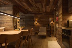 una cucina con pareti in legno, tavolo e sedie di Alpine Woodhouse a Valtournenche