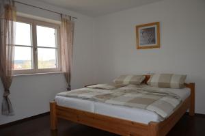 a bed in a white room with a window at Ferienhaus zur Tulpe, Legoland in Ettenbeuren
