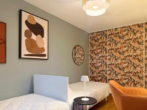 Zimmer mit 2 Betten und einer Wand mit einem Gemälde in der Unterkunft La Rose des Vents in Valence + 15 Fotos