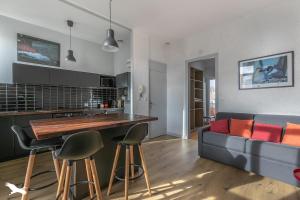 阿卡雄Arcachon Cœur de ville Appartement lumineux的配有沙发和桌子的厨房和客厅