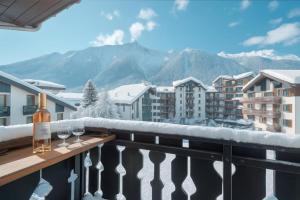 a couple of wine glasses on a balcony with mountains at Chamonix Sud - Bâtiment Iris 374 - Happy Rentals in Chamonix-Mont-Blanc +6 photos