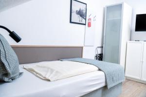 a bedroom with a white bed with a lamp on it at Stadt-gut-Hotel Rheinischer Hof in Essen