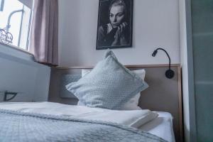 a bedroom with a bed and a portrait of a woman at Stadt-gut-Hotel Rheinischer Hof in Essen
