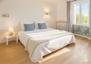 a bedroom with a large white bed with blue pillows at Maison cosy avec jardin, 4 chambres, Route du Vin in Nuits-Saint-Georges