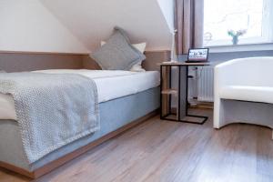 a bedroom with a bed and a table with a laptop on it at Stadt-gut-Hotel Rheinischer Hof in Essen