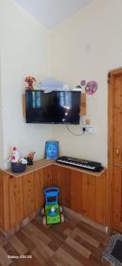 a room with a counter with a tv on the wall at Vidhi homestay in Kulu