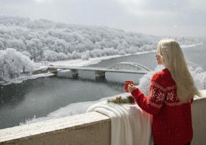 a woman standing on a ledge in the snow at Hotel Magnólia in Piešťany