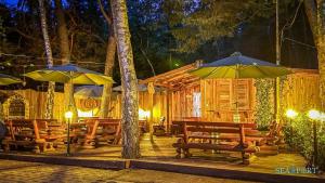 a wooden cabin with benches and umbrellas at night at SEA-PORT Resort in Łeba
