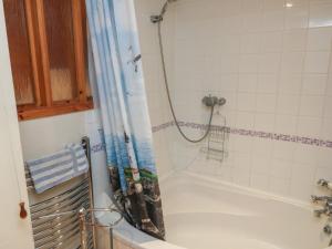 a bathroom with a tub and a shower curtain at Bridge Cottage in Budleigh Salterton +26 photos